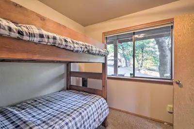 a bedroom with a bunk bed and a window at Deck and Grill Mtn Haven in Stanislaus Natl Forest in Arnold