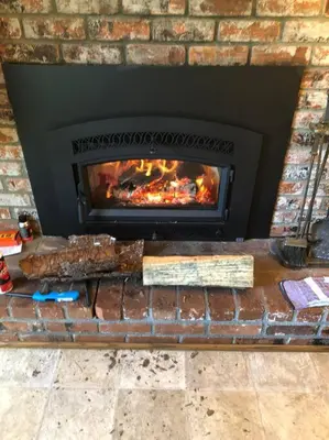 a brick fireplace with a fire in it at Lakeside BLS Retreat near Big Trees & Bear Valley in Arnold