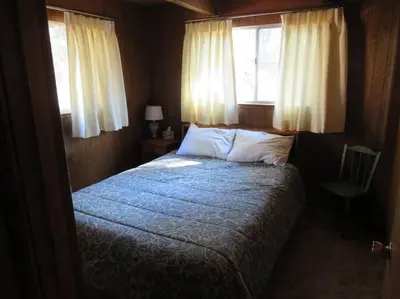 a bedroom with a bed and two windows at Lakeside BLS Retreat near Big Trees & Bear Valley in Arnold