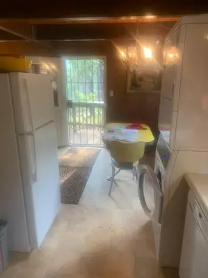 a small kitchen with a table and a refrigerator at Lakeside BLS Retreat near Big Trees & Bear Valley in Arnold