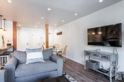 a living room with a couch and a tv on a wall at Highly updated 1 Bedroom plus den, 2 bath Crestview Unit 5 Sleeps up to 4 located near Canyon Lodge in Mammoth Lakes