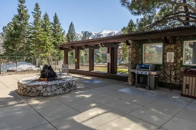 a patio with a stone building with a stove at Ski in Ski Out Juniper Springs Lodge #351 Luxury Slope-side 2 Bedrm 2 Bath End Unit! in Mammoth Lakes