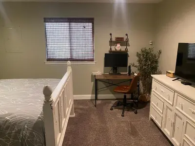 a bedroom with a bed and a desk and a television at Historic Washington St Balcony in Sonora