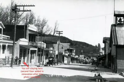 a black and white photo of a town street at Historic Washington St Balcony in Sonora
