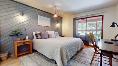 a bedroom with a bed and a table and a desk at Aspen Creek #115 condo in Mammoth Lakes