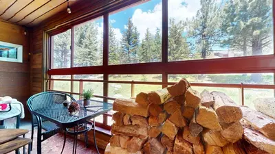 a room with a table and a pile of logs at Aspen Creek #115 condo in Mammoth Lakes