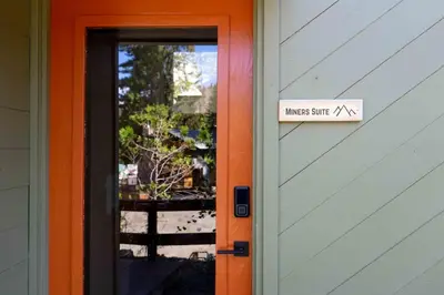 an orange door with a sign that readsmassimus suite at Miners Suite-Centrally Located in Shaver Lake in Shaver Lake