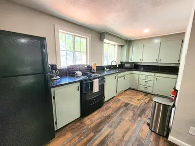 a kitchen with white cabinets and a black refrigerator at Miners Suite-Centrally Located in Shaver Lake in Shaver Lake