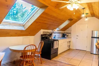 a kitchen with a table and a stove and a window at Hawks Nest- Perfect Getaway in Shaver Lake in Shaver Lake