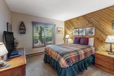 a bedroom with a bed and a tv and a window at Snowcreek 56 in Mammoth Lakes