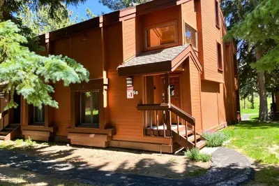 a wooden house with a staircase in front of it at Snowcreek 56 in Mammoth Lakes