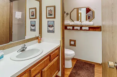 a bathroom with a sink and a toilet and a mirror at Snowcreek 56 in Mammoth Lakes