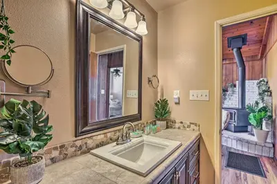 a bathroom with a sink and a mirror at Lovely Oakhurst Cabin with Deck and Mtn Views! in Oakhurst