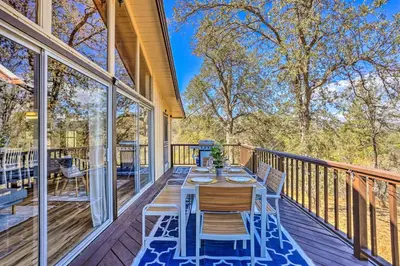 a patio with a table and chairs on a deck at Lovely Oakhurst Cabin with Deck and Mtn Views! in Oakhurst