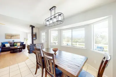 a dining room and living room with a table and chairs at Five Oaks Circle Ranch in Oakhurst