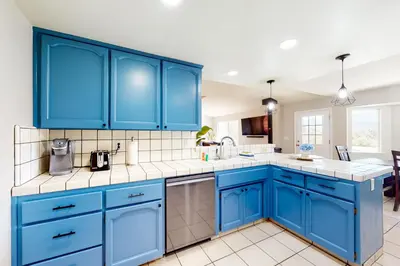 a blue kitchen with white counters and blue cabinets at Five Oaks Circle Ranch in Oakhurst