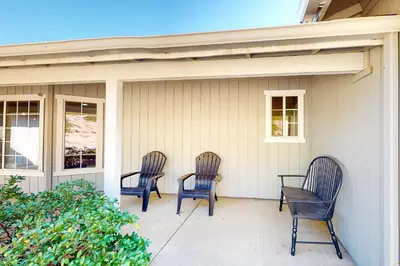three chairs sitting on the front porch of a house at Five Oaks Circle Ranch in Oakhurst
