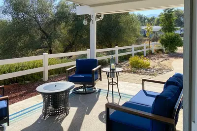 a porch with two chairs and a table at Five Oaks Circle Ranch in Oakhurst