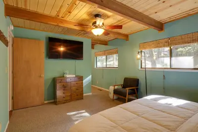a bedroom with a bed and a ceiling fan at Spacious Groveland Cabin with Wraparound Deck! in Groveland