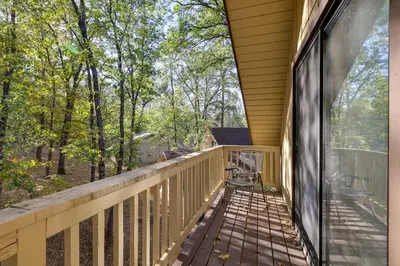 a balcony with a view of the woods at Spacious Groveland Cabin with Wraparound Deck! in Groveland