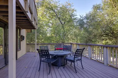 a patio with a table and chairs on a deck at Spacious Groveland Cabin with Wraparound Deck! in Groveland