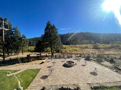 a patio with chairs and a fire pit in a field at Sierra Woods Lodge in Emigrant Gap