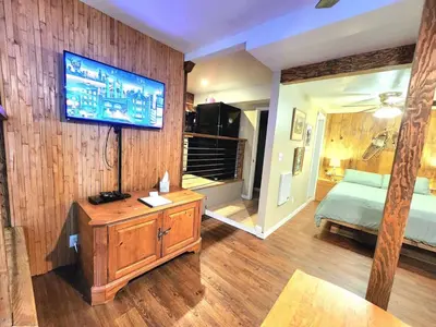 a bedroom with a bed and a television on a wall at Bear Cave- Pet Friendly Suite in Shaver Lake in Shaver Lake