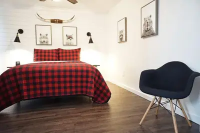 a bedroom with a bed and a black chair at Fox Den- Pet Friendly Suite in Shaver Lake in Shaver Lake