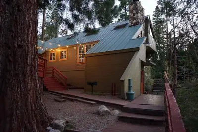 a small yellow house with a metal roof at Fox Den- Pet Friendly Suite in Shaver Lake in Shaver Lake