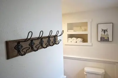 a bathroom with a toilet and a shelf with towels at Fox Den- Pet Friendly Suite in Shaver Lake in Shaver Lake
