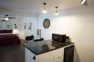 a room with a bed and a kitchen with a microwave at Fox Den- Pet Friendly Suite in Shaver Lake in Shaver Lake