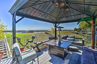 a patio with a table and a bike on a deck at Bethel Island Retreat with Private Boat Slip! in Bethel Island