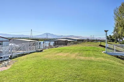 a large grassy field next to a building with a fence at Bethel Island Retreat with Private Boat Slip! in Bethel Island
