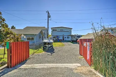 a house with a red fence and a boat in the driveway at Bethel Island Retreat with Private Boat Slip! in Bethel Island
