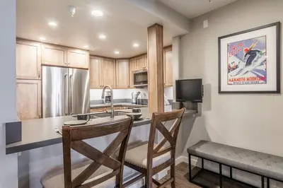 a kitchen with a counter with a sink and a refrigerator at Aspen Creek 121 in Mammoth Lakes