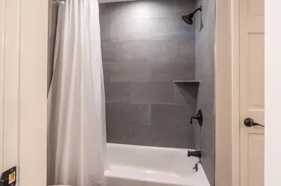 a bathroom with a shower with a white shower curtain at Aspen Creek 121 in Mammoth Lakes
