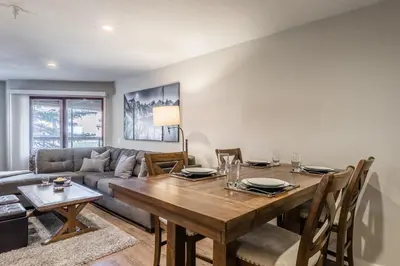 a dining room with a table and a couch at Aspen Creek 121 in Mammoth Lakes