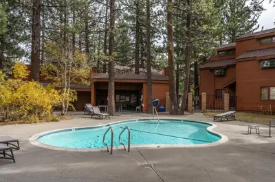 a swimming pool in front of a house at Updated 2 Bedroom and Loft 2 Full Bathroom Woodlands #51Just Steps to Shuttle Close to Golf Course in Mammoth Lakes