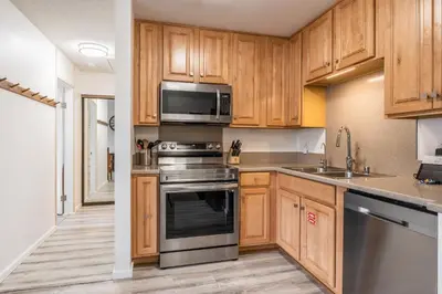 a kitchen with wooden cabinets and stainless steel appliances at Summit #256 - Top Floor Summit 1 Bedrm 1 Bathrm Condo Just steps too Little Eagle Lodge Sleeps 4 in Mammoth Lakes