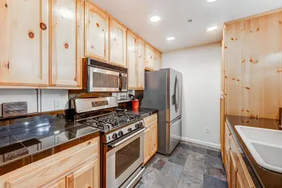 a kitchen with wooden cabinets and stainless steel appliances at Tavern Inn #39 in Olympic Valley