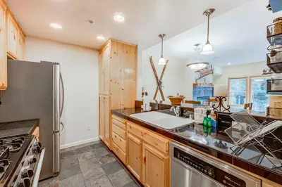 a kitchen with wooden cabinets and a stainless steel refrigerator at Tavern Inn #39 in Olympic Valley