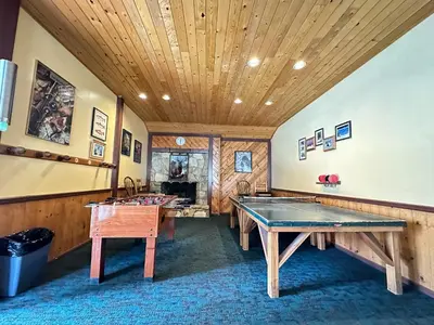 a room with two ping pong tables and a wooden ceiling at Lakeview Villas #28 condo in Mammoth Lakes