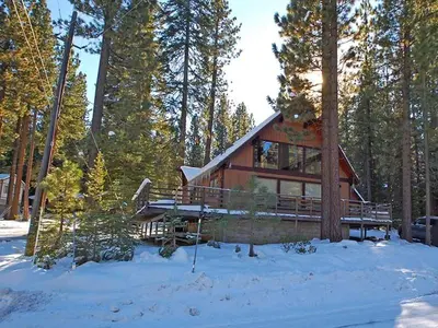 a log cabin in the woods in the snow at 1116 Golden Bear home in South Lake Tahoe