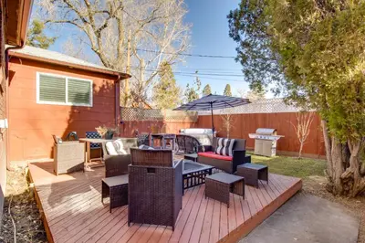 a deck with chairs and tables and an umbrella at Hot Tub and Walk to Midtown! Reno Retreat in Reno