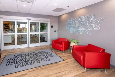 a waiting room with two red chairs and a happy anniversary mural at Hampton Inn Selma, Ca in Selma