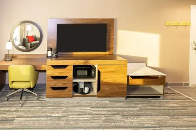 a living room with a television and a desk with a chair at Hampton Inn Selma, Ca in Selma