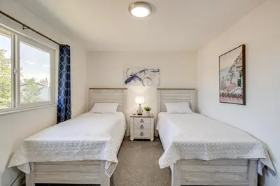two beds in a room with a window at Relax Fireside and Play Pool! Home 4 Mi to Dtwn Reno in Reno