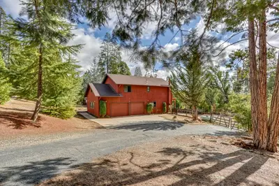 a red barn with a driveway and trees at Pet-Friendly Escape with Game Room and Fire Pit! in North Fork