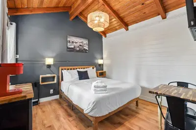 a bedroom with a large white bed and a table at Tahoe Mountain Inn in South Lake Tahoe