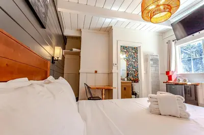 a bedroom with a large white bed and a table at Tahoe Mountain Inn in South Lake Tahoe